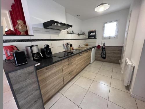a kitchen with wooden cabinets and a counter top at La plain' itude in Lacquy