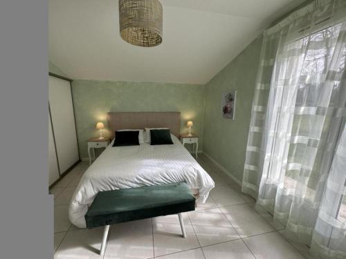 a bedroom with a bed and two tables with lamps at La plain' itude in Lacquy