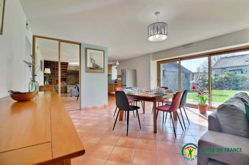 une salle à manger et un salon avec une table et des chaises dans l'établissement Casa camelias, à Limerzel