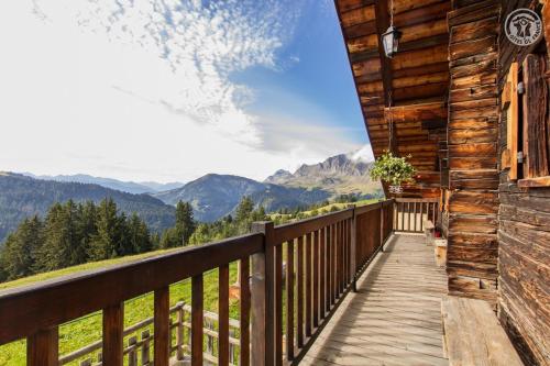 - un balcon en bois d'une cabane en rondins avec vue sur les montagnes dans l'établissement Le megevan-dans les alpages, à La Giettaz