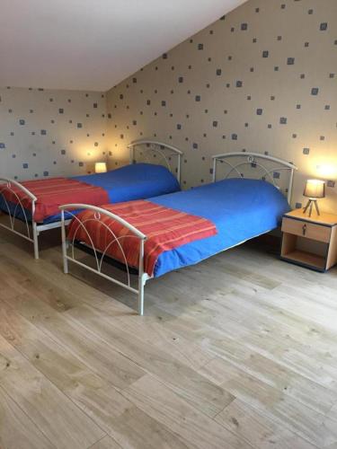 two beds in a bedroom with a wall with polka dots at La ferme d'ernest in Marnay