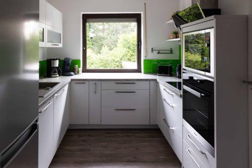 a kitchen with white cabinets and a window at Ferienwohnung Magnolia in Waldsassen
