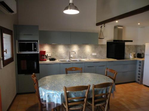 - une cuisine avec une table, des chaises et un évier dans l'établissement L' erable aux esperifes, à Vidauban