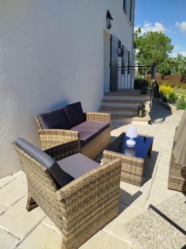 a patio with wicker chairs and a couch at La Tourelle Suite Cosy entre vignoble aixois et Luberon in Le Puy-Sainte-Réparade