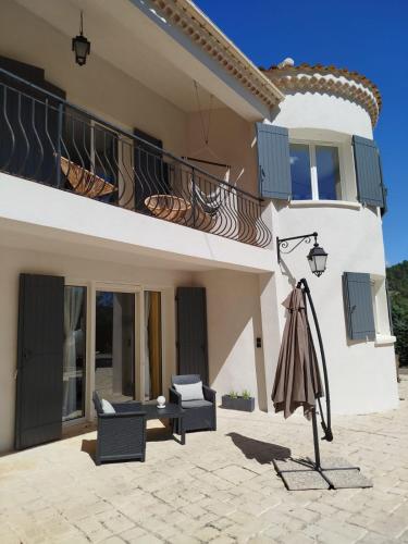a house with a dress on a rack in front of it at La Tourelle Suite Cosy entre vignoble aixois et Luberon in Le Puy-Sainte-Réparade