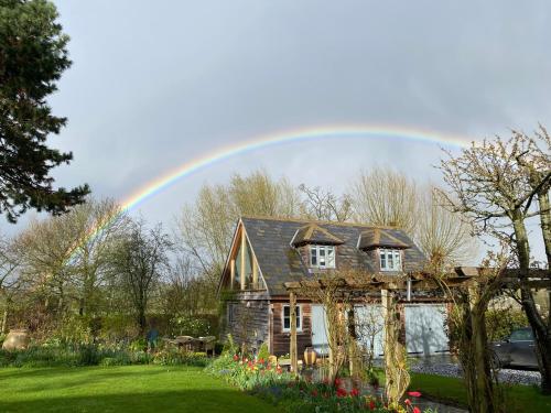 a rainbow in the sky above a house at Fabulous Barn in Great Wolford Moreton in Marsh in Shipston on Stour