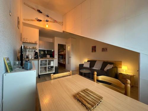 a kitchen and living room with a table and a couch at Le petit Marou in Saint-Lary-Soulan