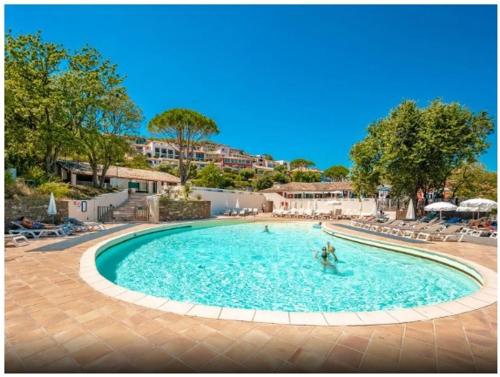 une grande piscine avec des gens dans l'eau dans l'établissement Maison Grimaud, à Grimaud