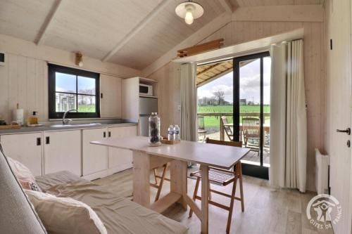 une cuisine avec une table et une salle à manger dans l'établissement Lodge des vignes, à Mézières-sur-Couesnon