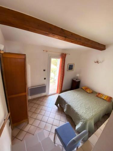 une chambre avec un lit et une chaise bleue dans l'établissement Domaine des fouques, à Hyères