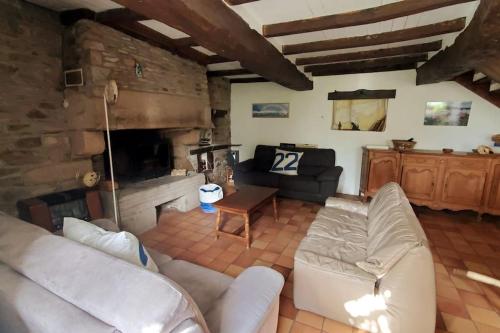 a living room with a couch and a fireplace at Grande maison de famille - Le Petit Pontébart in Paimpol