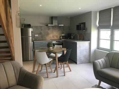 une cuisine et une salle à manger avec une table et des chaises dans l'établissement Le relais postal, à Celle-Lévescault