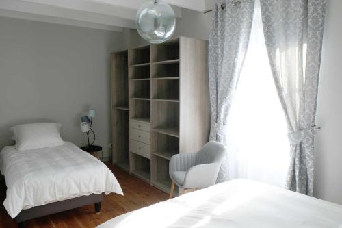 une chambre avec un lit, une chaise et une fenêtre dans l'établissement Le relais postal, à Celle-Lévescault