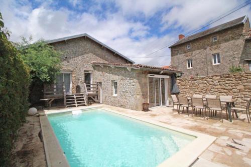 - une piscine en face d'une maison en pierre dans l'établissement Evasimone, à Châteauponsac