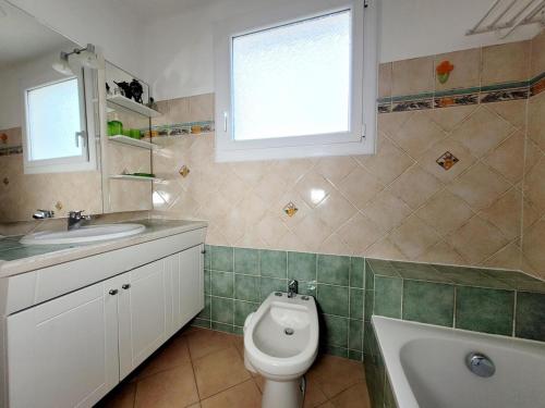 une salle de bain avec un lavabo et des toilettes et une fenêtre dans l'établissement Gîte Villa de 78 m2 à 400m de la plage + piscine, à Six-Fours-les-Plages