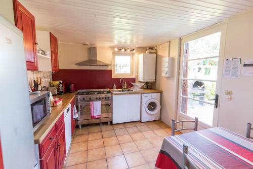 a kitchen with a stove and a washer and dryer at Gite de pernaout in Bélis
