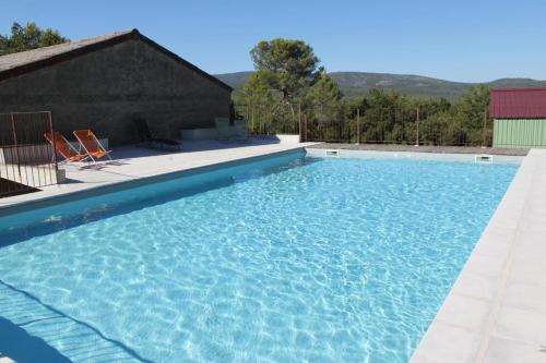 une grande piscine avec de l'eau bleue dans l'établissement domaine de la creche, à Nans-les-Pins
