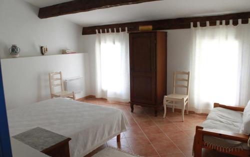 - une chambre avec un lit, 2 chaises et des fenêtres dans l'établissement domaine de la creche, à Nans-les-Pins