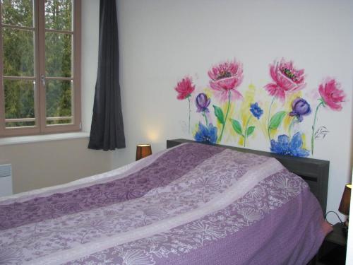 a bedroom with a purple bed with flowers painted on the wall at Le gite communal in Puilly-et-Charbeaux