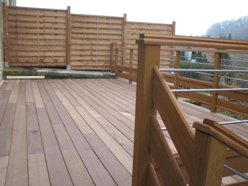 a balcony with wooden flooring and a wooden railing at Le gite communal in Puilly-et-Charbeaux