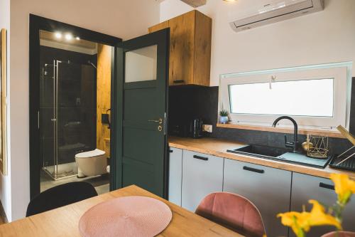a kitchen with a table and a green door at Domki Borys in Jastrzębia Góra