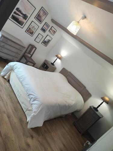 - une chambre avec un lit blanc et deux lampes dans l'établissement Gite de la haute roche, à Charroux