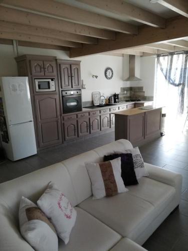 un salon avec un canapé blanc et une cuisine dans l'établissement Gite de la haute roche, à Charroux