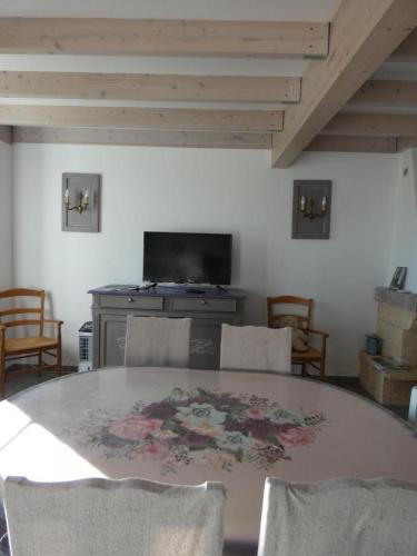 une salle à manger avec une table, des chaises et une cheminée dans l'établissement Gite de la haute roche, à Charroux