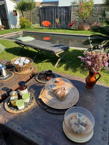 a table with plates of food on top of it at Maisons 322 - Maison L'Insolite in Le Bois-Plage-en-Ré