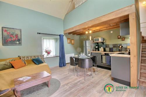 un salon avec un canapé et une cuisine dans l'établissement Le petit pen poulo, à Neulliac