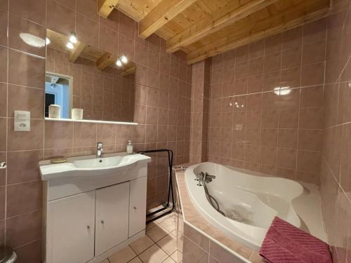 a bathroom with a sink and a bath tub at Grand aoulet in Accous