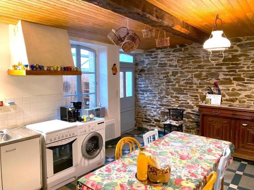 une cuisine avec une table et une cuisinière dans l'établissement Le petit gite, à Gespunsart