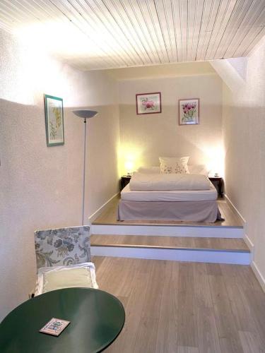 - une chambre avec un lit, une table verte et une chaise dans l'établissement Le petit gite, à Gespunsart