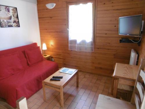 a living room with a red couch and a tv at La callune in Brocas