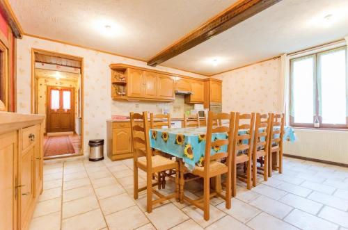 une cuisine avec une table et des chaises dans une pièce dans l'établissement Le moulin de la lhuitrelle, à Lhuître