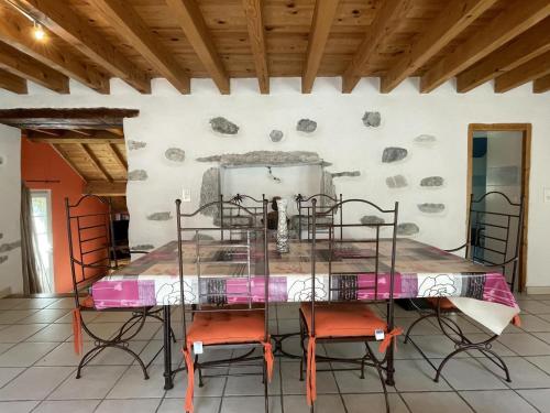 a table with chairs in a room with a wall at Petit aoulet in Accous