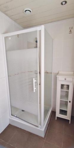 a glass shower door in a bathroom with a cabinet at La folie in Fumay