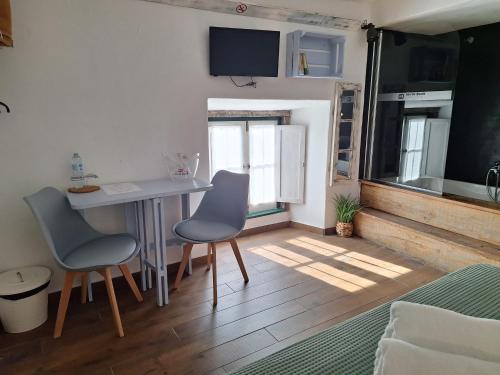 a kitchen with a table and two chairs in a room at Lovin Book Guesthouse in Óbidos