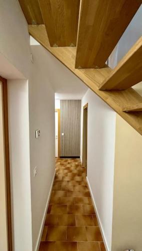 an empty hallway with wooden ceilings and a tile floor at LAntica Torre in Pontebba