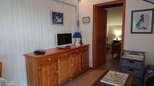 a living room with a television on a wooden dresser at Marina in Onard
