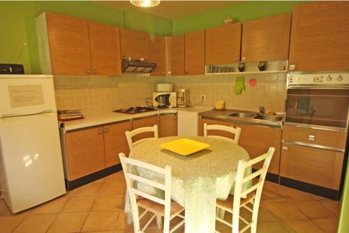 une cuisine avec une table, des chaises et un réfrigérateur dans l'établissement Bel air, à Nexon