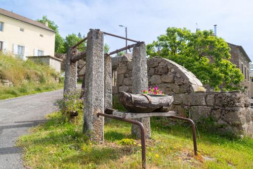 a stone fence with a flower pot on the side of a road at Gites de france 6 personnes a pierrefiche in Pierrefiche
