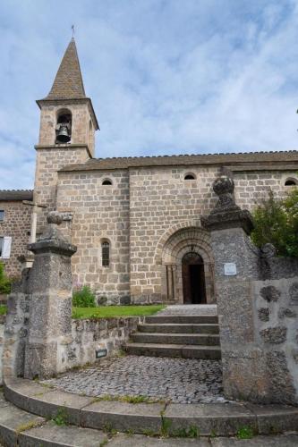 an old stone building with a church with a steeple at Gites de france 6 personnes a pierrefiche in Pierrefiche