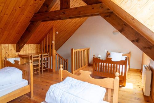 a attic room with two beds and a table at Gîte Gîtes de France 3 épis 6/7 pers à la Chaze in Pierrefiche