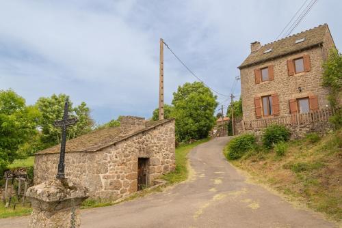 an old stone building on a hill next to a road at Gîte Gîtes de France 3 épis 6/7 pers à la Chaze in Pierrefiche