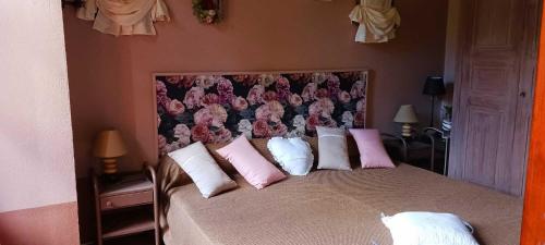 une chambre avec un grand lit avec des oreillers roses dans l'établissement Le murier a la bouverie, à Roquebrune-sur Argens