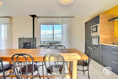 une cuisine et une salle à manger avec une table et des chaises en bois dans l'établissement Ty rigadeau, à Gâvres
