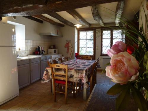 une cuisine avec une table recouverte d'une nappe dans l'établissement Les mere, à Targé