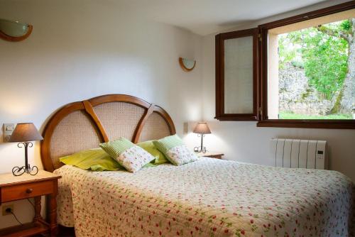 une chambre avec un lit avec des oreillers jaunes et une fenêtre dans l'établissement Gîte Gîte La Parro 2/4 personnes, à Cultures