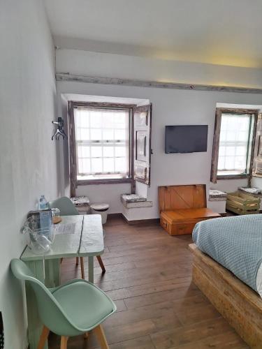 a bedroom with a bed and a table and chairs at Lovin Book Guesthouse in Óbidos